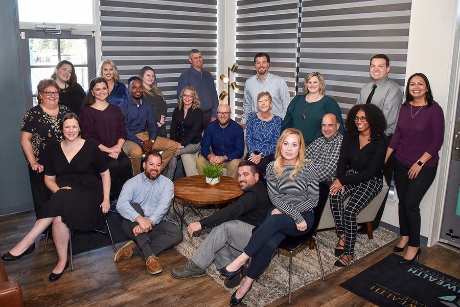 About Our Agency - Group Shot of the Commonwealth Insurance Services Team Sitting and Standing Together Inside Their Office